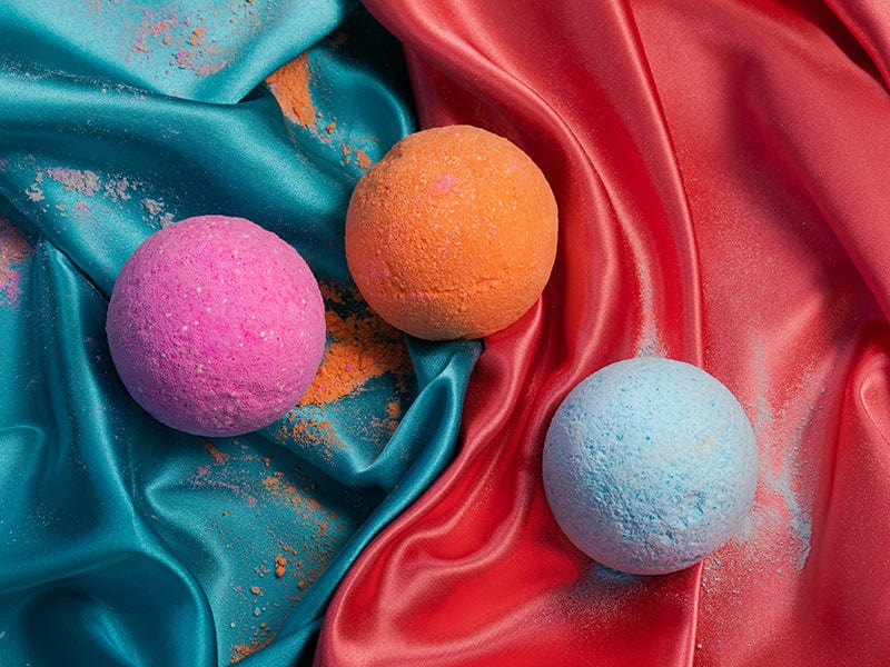Awaken, Citrus and Relax CBD Bath Bombs laying on a red and teal silk scarfs.